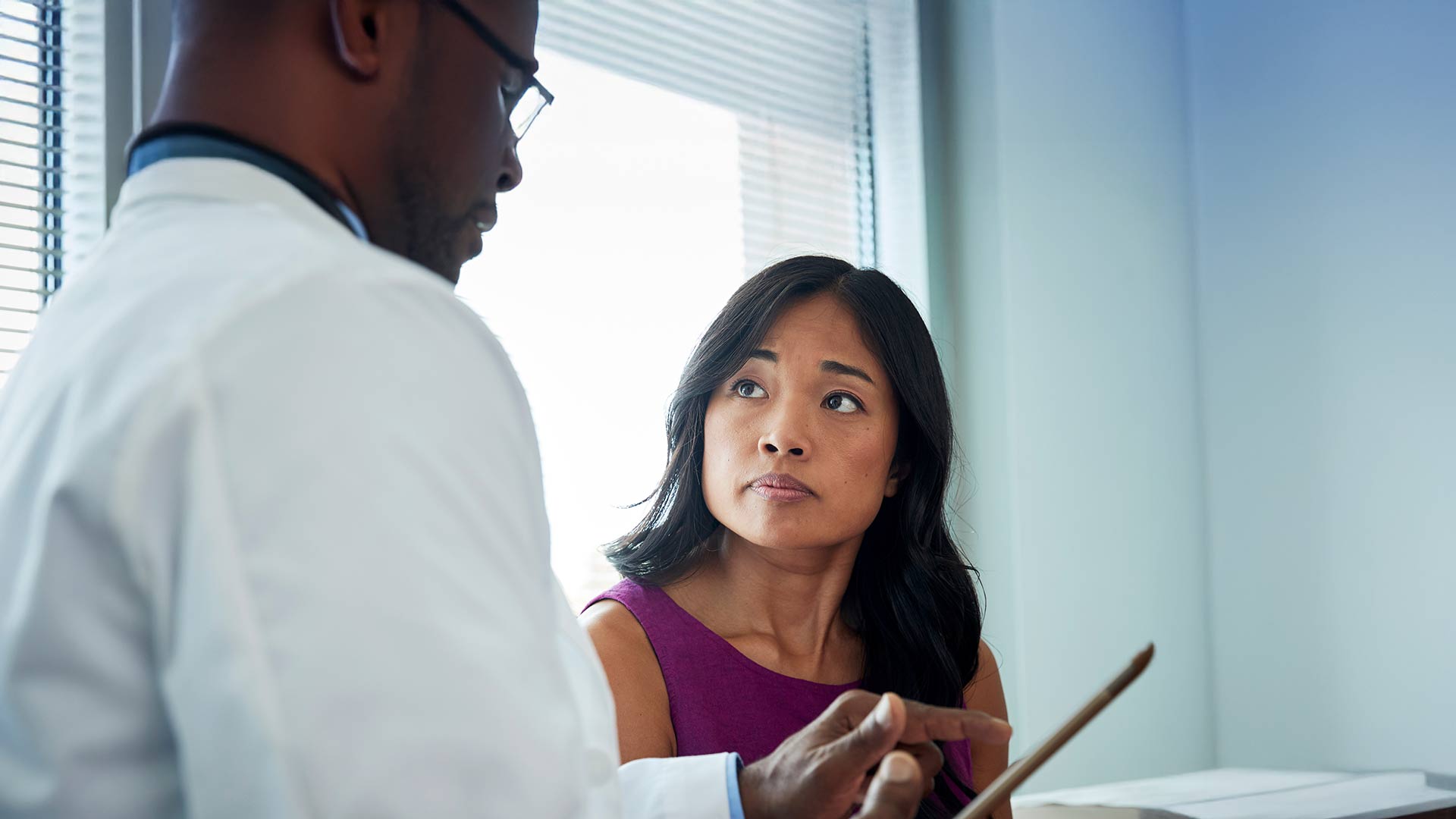 Doctor using tablet while discussing options with patient